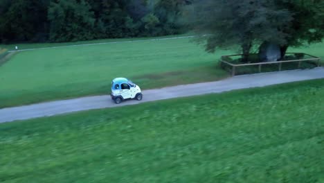 Cinematic-side-aerial-drone-shot-following-light-electric-vehicle-from-ENUU-in-Switzerland