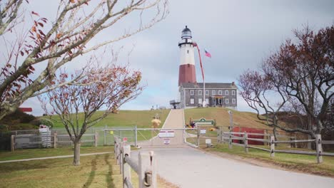 Wide-shot-of-the-Montauk-Point-lighthouse-from-the-front-gate-on-a-partly-cloudy-day