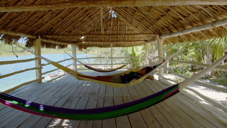 Slow-motion-of-girl-having-a-nap-on-hammock-inside-a-hut-in-Chunyaxche,-Quintana-Roo,-Mexico