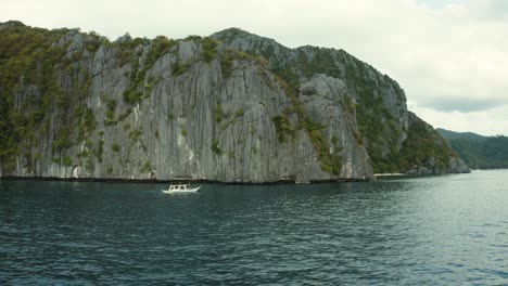 WS-AERIAL-Boat-in-sea-and-coastal-cliffs,-El-Nido,-Palawan,-Philippines