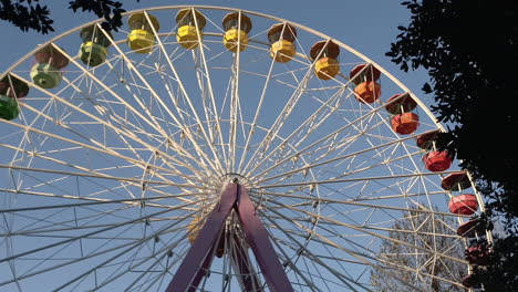 Tilt-down-of-colorful-ferris-wheel-stopped-at-amusement-park