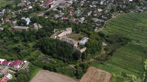 Aerial-View-of-Old-Abandoned-Building-Surrounded-by-Neighborhood-and-Trees