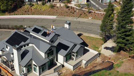 Installers-carrying-and-placing-solar-panels-into-place-on-roof-of-house