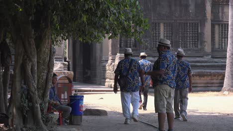 Wide-External-Shot-of-Tourist-Group-of-Gentlemen-Finishing-a-Conversation-Then-Walking-Towards-The-Temple-While-Wearing-the-Same-Flowery-Shirts-and-Hat