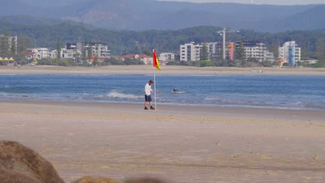 Lifeguard-Putting-Up-A-Warning-Flag-On-The-Beach-Shore---Surfing-At-Snapper-Rocks-Near-The-Rainbow-Bay---Coolangatta-,-Gold-Coast,-Queensland,-Australia---COVID-19