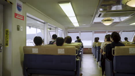 Slow-moving-panning-shot-of-tourists-taking-the-ferry-to-Itsukushima-island,-Miyajima,Japan