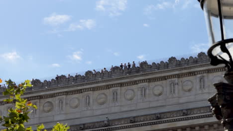View-from-the-ground-of-tourists-wearing-protective-face-masks-on-the-roof-of-the-Arc-de-Triomphe-Paris