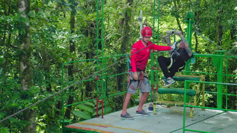 Zip-Lining-Instructor-Helping-Tourist-how-to-Zip-Line-Safely-in-Arenal,-Costa-Rica