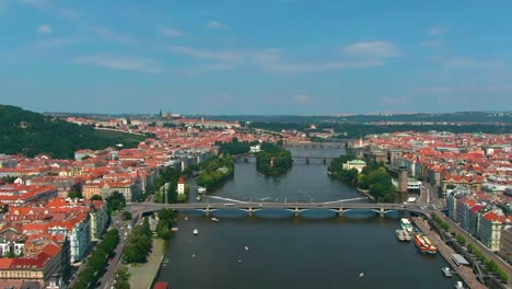 Prague-bridges-aerial-view-during-hot-summer-day,-with-boats-over-the-Vltava-river