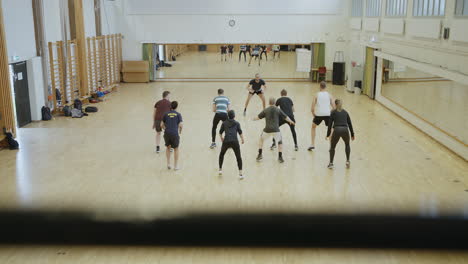 Slow-motion-dolly-shot-of-male-instructor-during-group-training