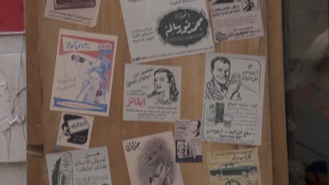 A-hip-novelty-cafe-and-store-in-Al-Qaysariya-Souq-in-Muharraq,-Bahrain-with-old-newspaper-ads-stuck-on-its-doors