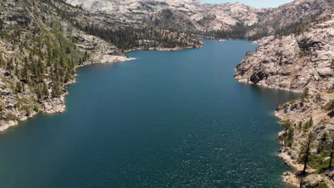 Expansive-aerial-of-a-large-high-Sierra-lake-in-California-surrounded-by-granite-and-pine-trees