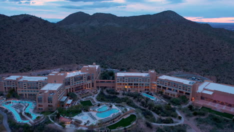 Drone-Dando-Vueltas-Sobre-Starr-Pass-Resort-And-Spa-En-Tucson,-Arizona-Con-Las-Montañas-Verdes-En-El-Fondo-Antes-Del-Amanecer