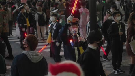 Shibuya-Halloween-–-Polizisten-Mit-Gesichtsmaske-Kontrollieren-Die-Menge-Mit-LED-Schlagstock-Und-Megaphon-In-Der-Halloween-Nacht-Am-Shibuya-Kreuzung-In-Tokio,-Japan