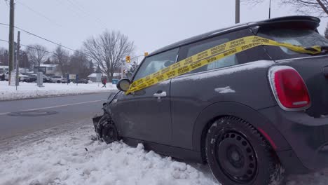 Small-vehicle-at-the-side-of-the-road-and-wrapped-in-police-tape-after-a-winter-accident