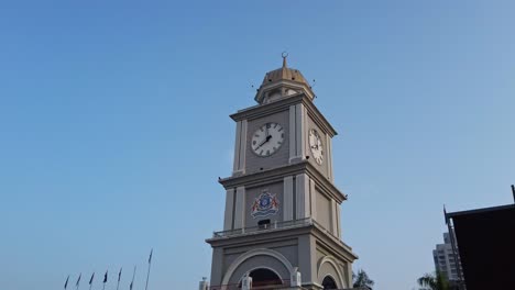 Orbit-shot-of-Johor-Bahru,-Malaysia-clock-tower-face-on-sunny-morning