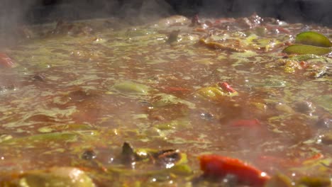 Cook-moves-a-Valencian-paella-with-the-shovel-while-the-broth-boils
