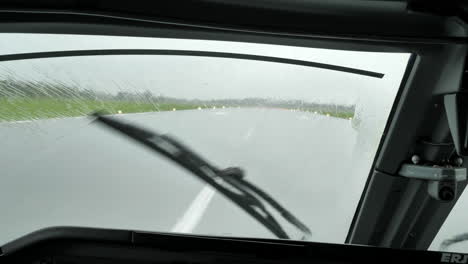 Wiper-Of-An-Airplane-Clearing-The-Windshield-From-Rain-Water-Upon-Landing-On-The-Airport-Runway-On-A-Bad-Weather---POV-shot