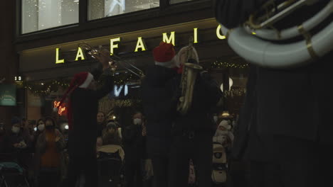 Street-musicians-dressed-like-Santa-Claus-plays-on-trumpets-and-saxophone