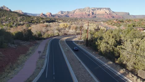 Aerial-tracking-shot-of-car-driving-highway-in-Red-Rocks-Valley-in-Sedona-USA