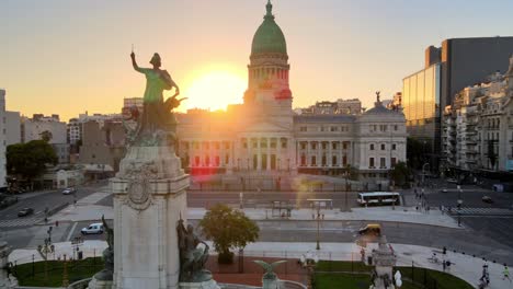 Aerial-pan-right-of-bronze-monument-in-Congressional-Plaza-revealing-Argentine-Congress-Palace-at-golden-hour,-Buenos-Aires