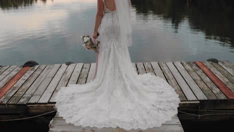 Braut-In-Einem-Eleganten-Hochzeitskleid-Steht-Am-Ende-Eines-Docks-Am-Lac-Viceroy-Lake-In-Montpellier,-Quebec,-In-Einem-Hochzeitsresort