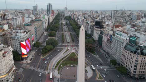 Obelisco-De-Buenos-Aires-Con-Vista-A-Los-Edificios-De-La-Ciudad-Y-Al-Tráfico-En-La-Intersección-Y-Vía-En-Buenos-Aires,-Argentina