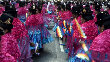 Blick-Aus-Der-Vogelperspektive-Auf-Bolivianische-Cholitas,-Die-In-Farbenfrohen-Kostümen-Mit-Wiphalas-Vorführen