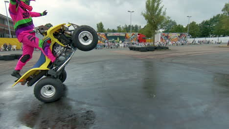 Quad-Bike-On-Rear-Wheel-With-Professional-Stunt-Driver-Standing
