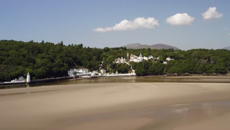 Drone-flying-past-Portmeirion-Village-on-the-Dfyd-Estuary-in-North-Wales,-Britain,-UK