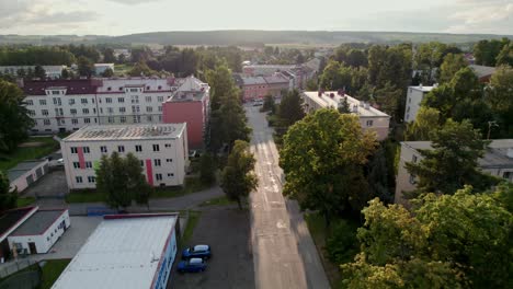 Slow-drone-flight-over-an-empty-street-with-trees-and-houses-at-sunset,-Czech-Republic