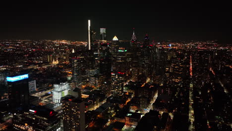 Aerial-truck-shot-of-urban-city-lit-up-at-night