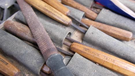 A-woodcarvers-woodworking-toolkit-full-of-high-quality-chisels,-slow-pan-from-left-to-right
