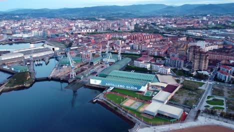 Drone-fly-above-the-port-in-gijon-revealing-the-cityscape-of-the-city-in-north-spain