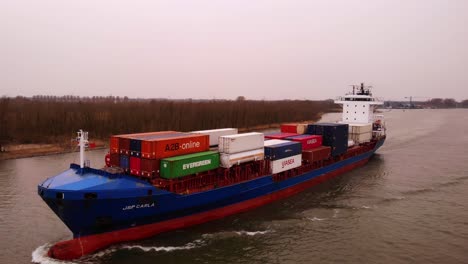 Aerial-View-Of-JSP-Carla-Cargo-Ship-Travelling-Along-Oude-Maas-On-Overcast-Day