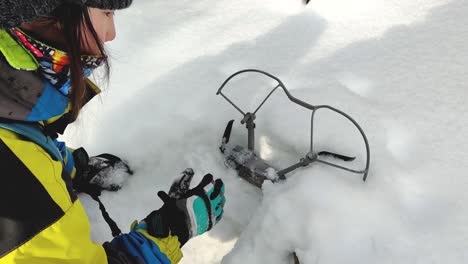 Excursionista-Femenina-Excavando-Un-Dron-Enterrado-En-La-Nieve-En-Hokkaido,-Japón