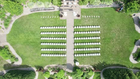 Drone-shot-coming-down-on-a-wedding-ceremony-setup-in-a-courtyard-garden