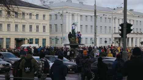 People-celebrating-Olympic-Ice-hockey-gold-medal,-at-the-Havis-Amanda-statue,-in-Helsinki,-Finland