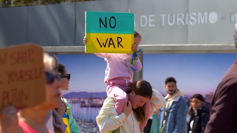 Close-up-of-Ukrainian-child-sisters-holding-up-"No-War"-sign-during-protests
