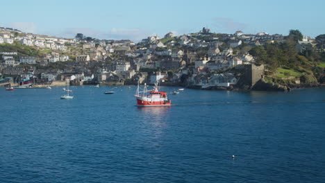 Cornish-Fishing-Trawler-Boat-Returns-back-to-Shore-at-Polruan-Coastal-village-Harbour,-Cornwall---wide-shot