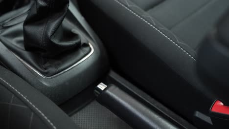 Hand-of-person-release-hand-brake-in-his-vehicle,-close-up-view