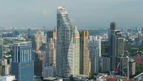 4K-Urban-landscape-shot-of-a-panoramic-view-of-buildings-and-skyscrapers-in-downtown-Bangkok,-Thailand-during-sunset-from-a-rooftop