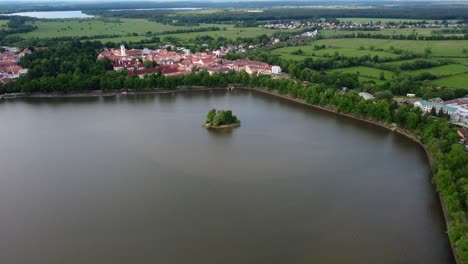 Aerial-footage-of-a-small-historic-town-Trebon-surrounded-by-a-big-pond-with-islet