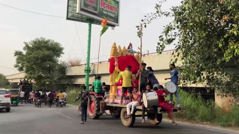 Devotees-take-the-idol-of-a-Hindu-God-on-a-tractor-with-music-and-drum-beats-in-New-Delhi