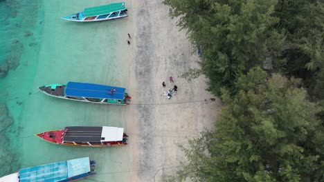 Luftaufnahmen-Von-Booten,-Die-An-Einem-Weißen-Sandstrand-Im-Wunderschönen-Türkisfarbenen-Wasser-Auf-Den-Gili-Trawangan-Inseln-In-Indonesien-Verankert-Sind