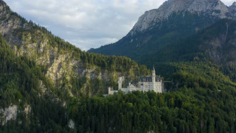 Perfect-white-castle-in-the-middle-of-the-mountains,-surrounded-by-forest-trees