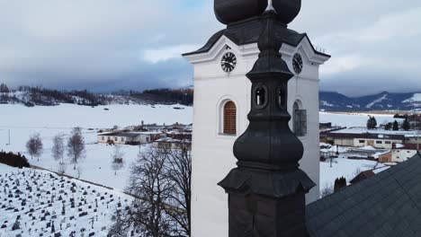 Aerial-shot-of-church,-during-winter,-near-village