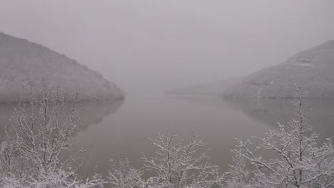 Overcast-and-Snowing-Day-by-Lake-Drone-Push-In-Shot