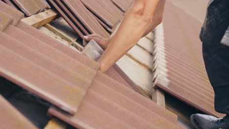 Closeup-of-worker-removing-roof-tiles-for-home-solar-panel-installation