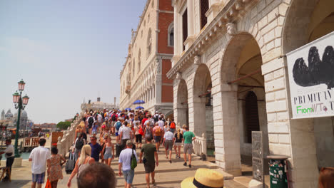 Gente-Caminando-Frente-Al-Palacio-De-Prisiones-Hasta-El-Puente-Paglia-En-Venecia,-Italia